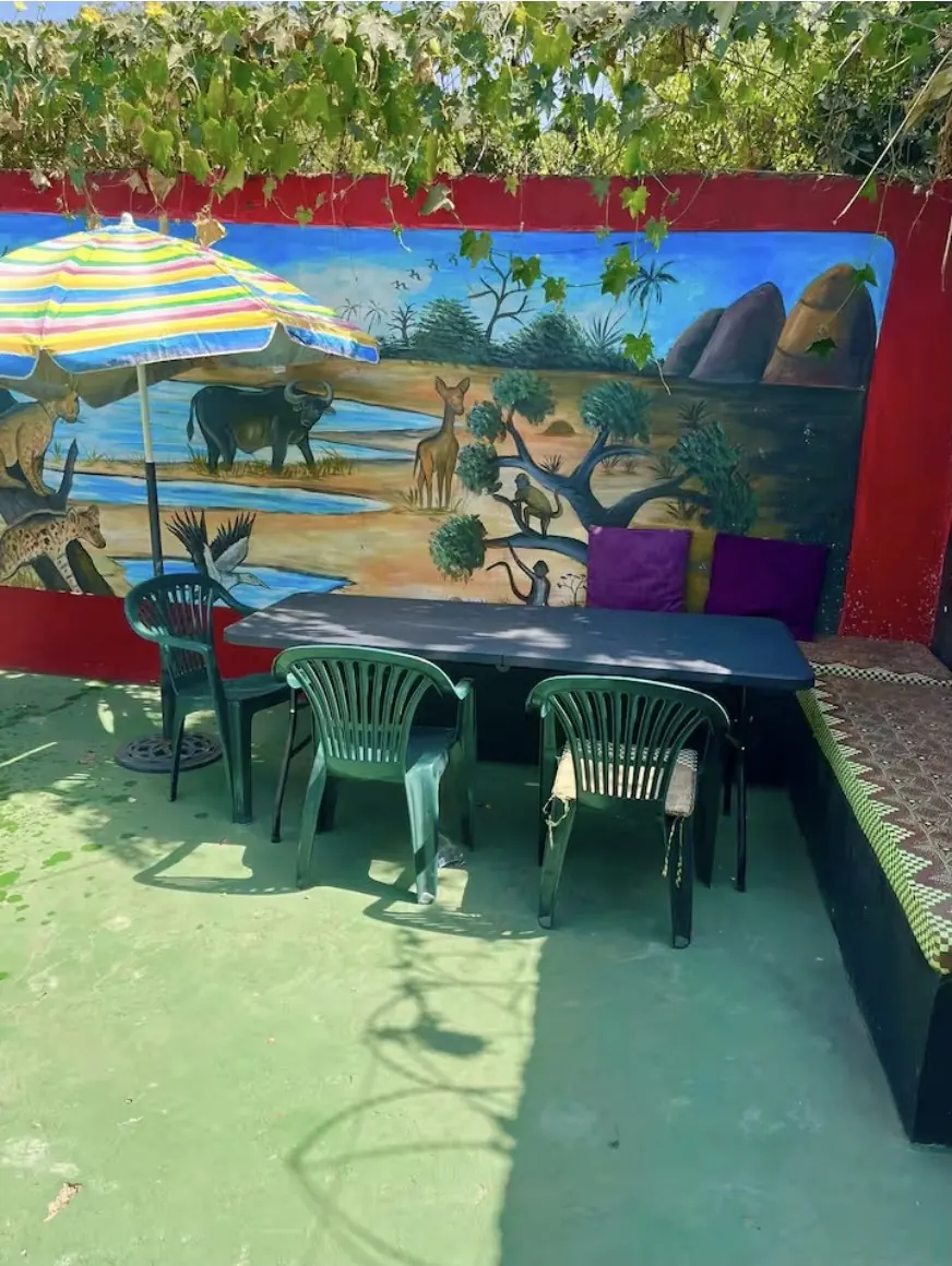 Outdoor dining table beside a painted African wildlife mural