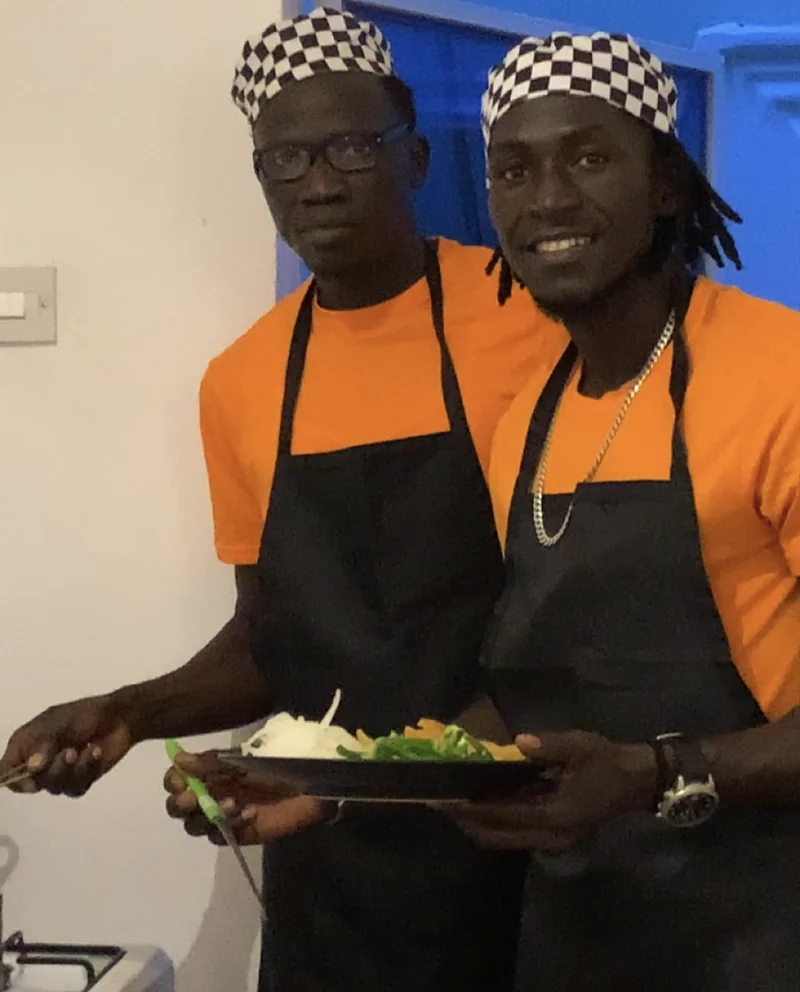 Papis and a friend in the kitchen, smiling and ready to welcome guests
